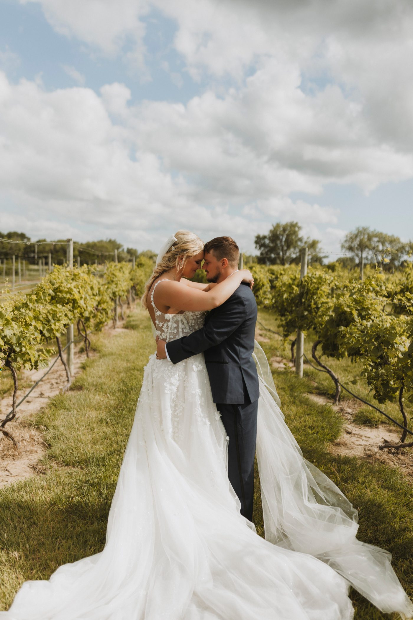 A bride and groom embrace in Moonlight Ridge Vineyards